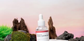 Zbliżenie butelki serum Heartleaf na trądzik, wśród naturalnych dodatków